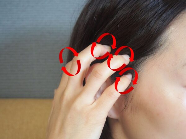 両手の指を側頭部にセット